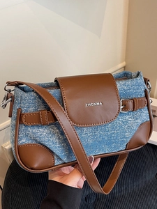 Vintage denim underarm bag with brown leather trim and silver brand logo detail