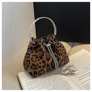 Detail view of leopard print bucket bag with silver metal ring handle and fringe
