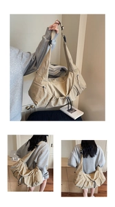 Detail view of large khaki nylon crossbody bag with adjustable buckle and functional pockets