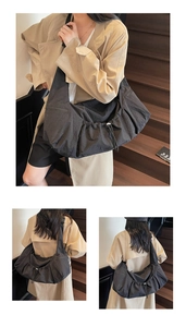 Detail showing oversized black nylon tote bag with drawstring texture and soft pleats