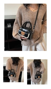 Detail of black glossy shoulder bag featuring brown plush bear patch and lace trim detail