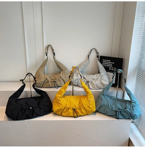 Detail view of colorful nylon crossbody bags in multiple colors with pleated design