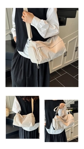 Detail of cream nylon pleated barrel bag with adjustable strap and side zipper pocket