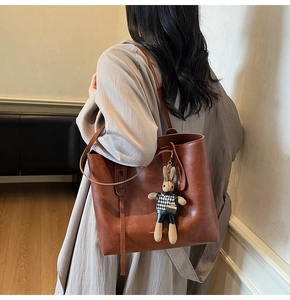 Dettaglio della grande borsa tote in pelle marrone scuro con ciondolo a forma di coniglio