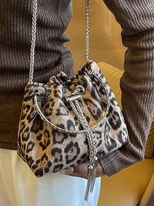 Leopard print bucket bag with silver chain strap and round metal handle shown on model