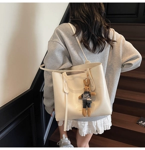 Dettaglio della grande borsa tote bianco crema con spalline lunghe e charm coniglio