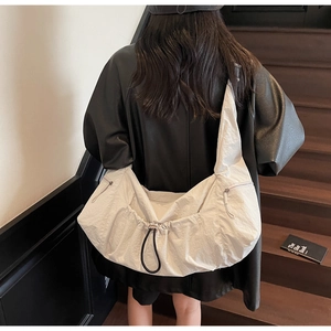 Detail of off-white oversized tote bag with drawstring and natural crinkle texture