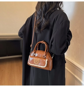 Brown PU leather crossbody bag with plush bear patch and lace trim detail on model