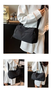 Detail of black cylindrical crossbody bag with waterproof nylon texture and wide strap