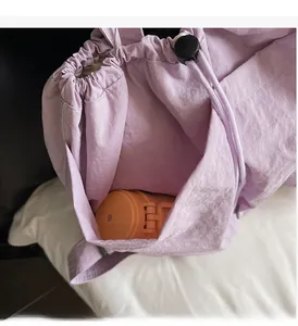 Detail showing the side pocket of a purple nylon backpack with a water bottle inside