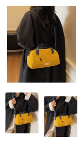 Detail view of mustard yellow crossbody pillow bag with grey handles and black straps