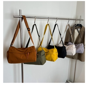 Macro detail of high-capacity nylon tote bags in six colors hanging for daily commute