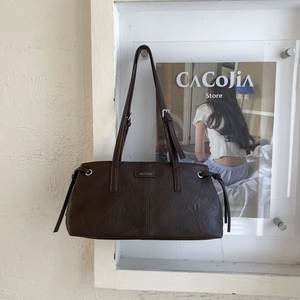 Dettaglio borsa tote marrone scuro con logo in metallo MUTING e texture con coulisse