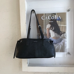 Dettaglio della borsa in pelle nera con logo MUTING in metallo e fibbia argento regolabile