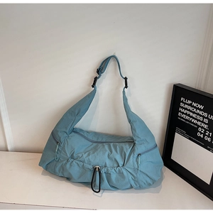 Macro view of light blue nylon tote bag showing waterproof texture and zipper details