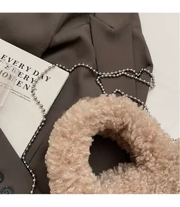 Detail of soft light camel faux fur handbag with a sleek silver metal bead chain strap