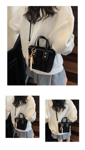 Detail view of mini black bucket bag with star patterns and a unique beaded charm