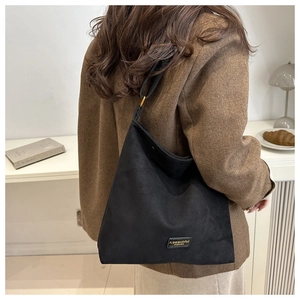 Detailed close-up of a vintage black matte bucket bag with a stylish leather brand tag