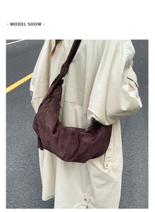 Detail view of coffee suede crescent bag showing knotted shoulder strap and vintage texture