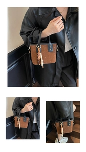 Detailed view of a brown suede bucket bag with star patterns and beaded tassels