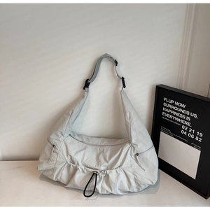 Detail of adjustable strap buckle and drawstring closure on large grey nylon tote bag