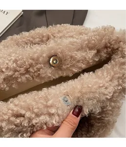 Close-up of plush faux shearling texture with a magnetic metal clasp and soft lining