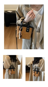 Detail of a brown bucket bag with embossed patterns and beaded pendant accessory
