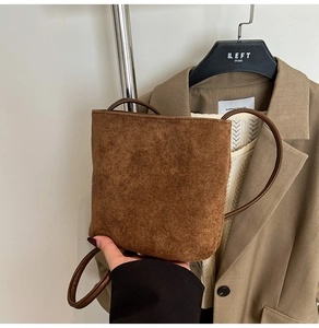 Detail view of the brown frosted suede bucket bag shown in a daily lifestyle outfit context