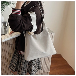 Détail du sac à bandoulière en cuir PU crème mat avec logo et texture fine