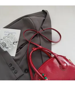 Vue de dessus d'un sac oreiller rouge foncé brillant avec des charms colorés tendance