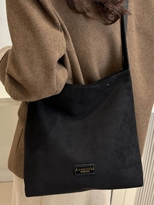 Retro black suede tote bag with shoulder strap and minimalist fashion label design