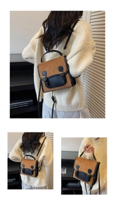 Detail view of retro brown and black leather backpack with flap and dual buckle straps