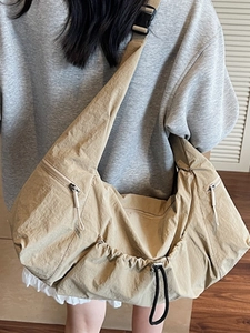Large khaki drawstring tote bag with adjustable strap and multiple zipper pockets