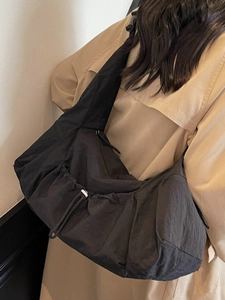 Large black minimalist nylon tote bag with drawstring design shown on a female model