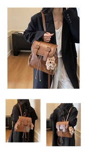 Nahaufnahme brauner Lederrucksack mit Kordelzug und einem süßen Teddybären-Anhänger-Detail