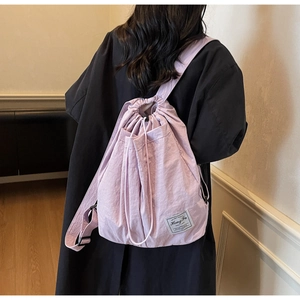 Detail view of lavender drawstring backpack with high-density fabric and woven logo tag