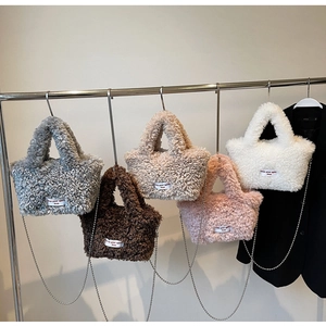 Close-up of fluffy faux fur tote bags in five colors with silver chain straps and logo tags