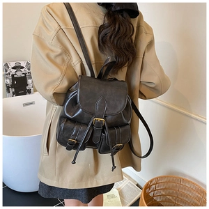Detail of vintage black faux leather backpack with flap closure and double front pockets