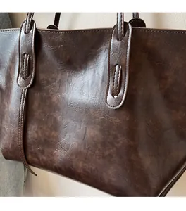 Close-up of dark brown tote bag showing durable PU leather texture and neat stitching details