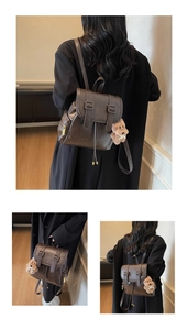 Detailansicht des Vintage-Lederrucksacks in Braun mit Schnallen und Plüschbär-Anhänger