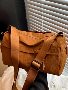 Minimalist brown nylon tote bag with adjustable strap and stylish wrinkled texture