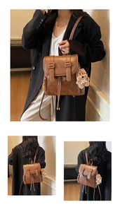 Nahaufnahme des braunen Vintage PU-Leder Rucksacks mit Schnallen und Plüschbär-Anhänger