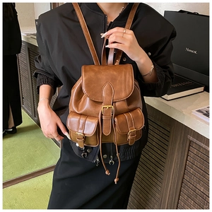 Brown vintage faux leather backpack featuring golden buckles and symmetrical pockets