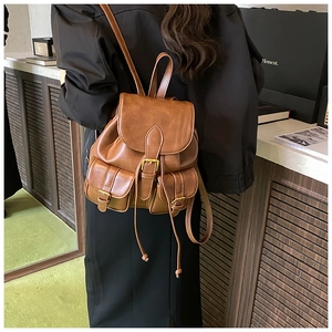 Rear view of a model wearing the brown vintage leather backpack with dual front pockets