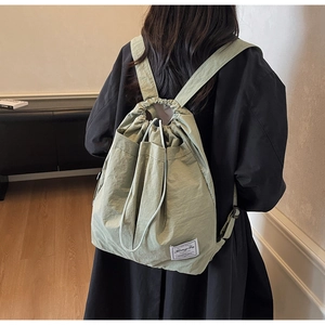 Close-up of grass green drawstring backpack made of water-resistant nylon material
