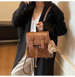 Nahaufnahme brauner Lederrucksack im Vintage-Stil mit Kordelzug und Plüsch-Hund-Anhänger