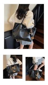 Detail view of a black faux leather tote bag with a checkered teddy bear charm accessory