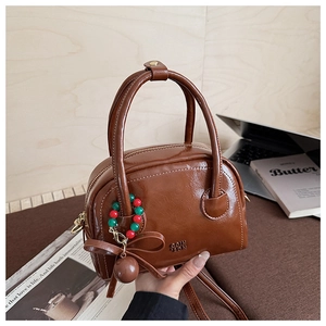 Détail d'un sac oreiller rétro marron brillant avec nœud papillon et pendentifs