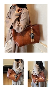 Close-up detail of a brown PU leather tote bag with a cute plush rabbit pendant charm
