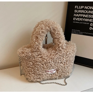 Close-up of beige plush tote bag with fuzzy texture and silver beaded chain strap